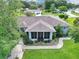 Aerial view of a well-maintained property with a large lawn, mature trees, and a screened lanai at 10086 Sw 62Nd Terrace Rd, Ocala, FL 34476
