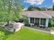 Beautiful aerial view of the backyard featuring a brick patio, lawn, and mature shade trees at 10086 Sw 62Nd Terrace Rd, Ocala, FL 34476