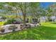 Spacious backyard featuring a brick patio with seating, lush lawn, and mature shade trees, perfect for outdoor living at 10086 Sw 62Nd Terrace Rd, Ocala, FL 34476