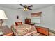 Cozy bedroom featuring a ceiling fan, wood-look floors, and a window with floral curtains at 10086 Sw 62Nd Terrace Rd, Ocala, FL 34476