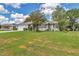 Exterior view of a home with a sprawling green lawn, mature landscaping, and a clean, modern facade at 10086 Sw 62Nd Terrace Rd, Ocala, FL 34476
