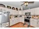 Bright kitchen featuring stainless steel appliances, wood-look flooring, and unique decor atop cabinets at 10086 Sw 62Nd Terrace Rd, Ocala, FL 34476