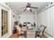 Inviting screened patio with ceiling fan, comfortable seating, and a table, perfect for outdoor dining and relaxation at 10086 Sw 62Nd Terrace Rd, Ocala, FL 34476