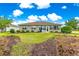 Charming home featuring a well-manicured lawn and a beautiful backyard with manicured garden at 10597 Sw 90Th Street Rd, Ocala, FL 34481
