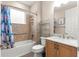 Bathroom with a bathtub and shower combination, wooden vanity, and tiled walls at 10597 Sw 90Th Street Rd, Ocala, FL 34481