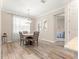 Cozy dining area featuring modern chandelier, wooden table with chairs, and view to a bedroom at 10597 Sw 90Th Street Rd, Ocala, FL 34481
