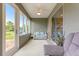 Screened lanai with comfortable seating, offering a peaceful view of the backyard and natural light at 10597 Sw 90Th Street Rd, Ocala, FL 34481