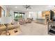 Open concept living room with ceiling fan and sliding doors to lanai, open to the kitchen and dining at 10597 Sw 90Th Street Rd, Ocala, FL 34481