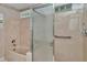 Bathroom featuring a tub/shower combo with glass doors and floral wallpaper at 10819 Sw 84Th Ter, Ocala, FL 34481