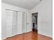 Bedroom with wood floors, closet, and a door to the bathroom at 10819 Sw 84Th Ter, Ocala, FL 34481