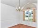 Dining room with wood floors and wainscoting, illuminated by a vintage brass chandelier at 10819 Sw 84Th Ter, Ocala, FL 34481