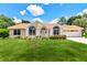 Charming single-story home with a manicured lawn, lush landscaping, and a welcoming entrance at 10819 Sw 84Th Ter, Ocala, FL 34481