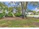 Inviting front yard featuring a tranquil bench nestled beneath mature trees at 10819 Sw 84Th Ter, Ocala, FL 34481