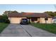 Inviting single-story home showcasing a well-manicured lawn and a paved driveway leading to a two-car garage at 10885 Se 74Th Ct, Belleview, FL 34420