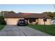 Charming single-story home featuring a well-maintained lawn and driveway with a two-car garage at 10885 Se 74Th Ct, Belleview, FL 34420