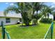 Well-maintained backyard with lush green grass and tropical landscaping at 12178 Se 174Th Pl, Summerfield, FL 34491