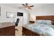 Bright bedroom featuring wood-look floors, ceiling fan, desk, and comfortable bed at 12178 Se 174Th Pl, Summerfield, FL 34491