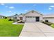 Charming home featuring a well-kept lawn, mature landscaping, and a two-car garage at 12178 Se 174Th Pl, Summerfield, FL 34491