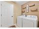 Functional laundry room with washer, dryer, and shelving for storage at 12178 Se 174Th Pl, Summerfield, FL 34491