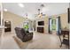 Bright living room with light wood flooring, ceiling fans, and sliding glass doors to the backyard at 12178 Se 174Th Pl, Summerfield, FL 34491