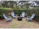 Backyard patio area with four Adirondack chairs surrounding a fire pit at 1245 Nw 73Rd Ter, Ocala, FL 34482
