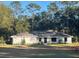 Charming single-story home featuring a neutral palette, well-maintained lawn, and lush surrounding trees at 1245 Nw 73Rd Ter, Ocala, FL 34482