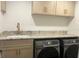 Functional laundry room with granite countertop, sink, and modern washer and dryer at 1245 Nw 73Rd Ter, Ocala, FL 34482