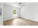Bedroom featuring a ceiling fan, wood laminate flooring, and window views at 14876 Se 34Th Ter, Summerfield, FL 34491
