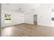 Spacious living room with hardwood floors, white walls, and a ceiling fan at 14876 Se 34Th Ter, Summerfield, FL 34491