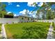 Expansive backyard featuring lush lawn, white fence, and meticulous landscaping for outdoor enjoyment at 155 Marion Oaks Pass, Ocala, FL 34473