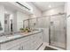 Bright bathroom features double vanity, large mirror, and glass-enclosed walk-in shower at 155 Marion Oaks Pass, Ocala, FL 34473