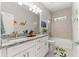 Bright bathroom featuring double sinks with granite countertops and tiled shower over tub at 155 Marion Oaks Pass, Ocala, FL 34473