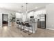 Bright kitchen featuring stainless steel refrigerator, island with bar stool seating, and pendant lighting at 155 Marion Oaks Pass, Ocala, FL 34473