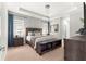Bright main bedroom boasts large bed with bench, soft carpet and decor, and natural lighting at 155 Marion Oaks Pass, Ocala, FL 34473