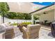 Inviting outdoor patio area with stylish furniture, sun shade, and ceiling fan, perfect for relaxation at 155 Marion Oaks Pass, Ocala, FL 34473