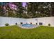 Backyard with a fenced perimeter, manicured lawn, and a tranquil in-ground spa for relaxation at 155 Marion Oaks Pass, Ocala, FL 34473