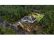 Aerial view of gray-roofed home with an attached garage, surrounded by lush trees and a gray driveway at 158 Guava Pass, Ocklawaha, FL 32179