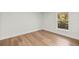 Bright bedroom with wood-look flooring and window view to the outdoors at 158 Guava Pass, Ocklawaha, FL 32179