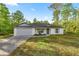 Charming single-story home with green door, blue shutters, and paved driveway at 158 Guava Pass, Ocklawaha, FL 32179