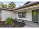 Inviting front porch with a beautiful door, blue shutters, and lovely landscaping at 158 Guava Pass, Ocklawaha, FL 32179