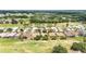 Aerial view of a neighborhood with golf course, featuring well-maintained homes surrounded by green spaces at 16023 Sw 14Th Avenue Rd, Ocala, FL 34473