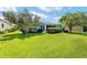 Beautiful backyard features a well-maintained lawn, mature trees, and charming screened lanai at 16023 Sw 14Th Avenue Rd, Ocala, FL 34473