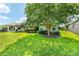 Lush backyard showcasing a mature tree, well-manicured lawn, and cozy seating area at 16023 Sw 14Th Avenue Rd, Ocala, FL 34473