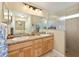 Bathroom with double sinks, a glass enclosed shower, and wood cabinets at 16023 Sw 14Th Avenue Rd, Ocala, FL 34473