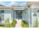 Inviting front entrance with a teal door, wreath, and manicured landscaping at 16023 Sw 14Th Avenue Rd, Ocala, FL 34473