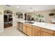 Open kitchen with stainless appliances, light wood cabinets, quartz countertops and a view to the living room at 16023 Sw 14Th Avenue Rd, Ocala, FL 34473