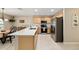 Well-lit kitchen with stainless steel appliances, light wood cabinets and an island with a long countertop at 16023 Sw 14Th Avenue Rd, Ocala, FL 34473