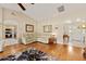 Bright living room featuring an archway to the kitchen, hardwood floors, and white furniture at 16023 Sw 14Th Avenue Rd, Ocala, FL 34473