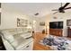 Spacious living room with hardwood floors, ceiling fan and large television at 16023 Sw 14Th Avenue Rd, Ocala, FL 34473