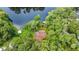 Beautiful aerial view of the house nestled among lush trees, facing a tranquil lake with private dock at 19620 Fox Trl, Dunnellon, FL 34432